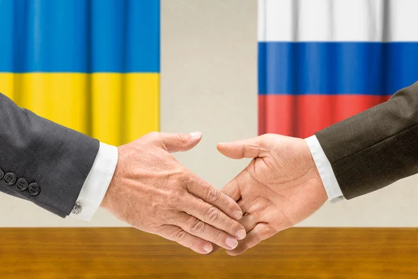 Vertegenwoordigers van Oekraïne en Rusland schudden handen — Stockfoto