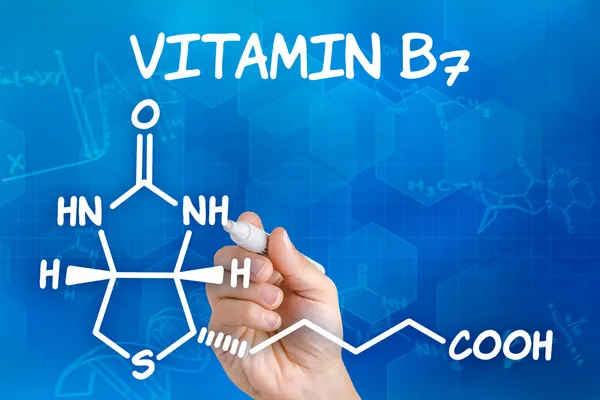 Hand with pen drawing the chemical formula of Vitamin B7 — Stock Photo, Image