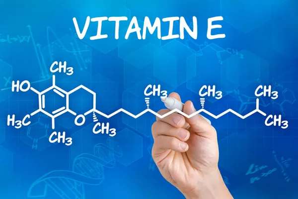 Hand with pen drawing the chemical formula of Vitamin E — Stock Photo, Image