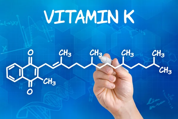 Mão com caneta desenhando a fórmula química da vitamina K — Fotografia de Stock