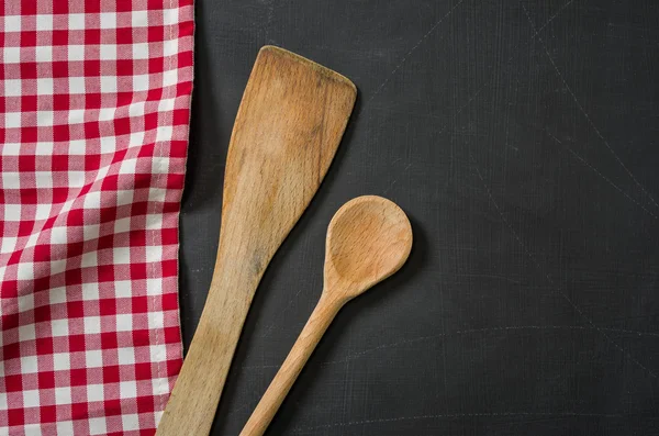 Cuchara de madera en una pizarra con un mantel a cuadros rojo — Foto de Stock