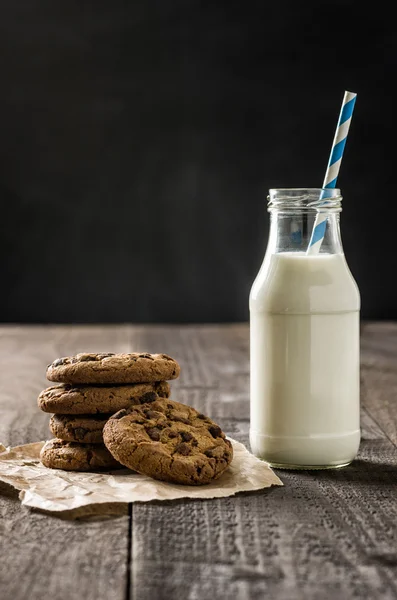 Chocolate cookies and a bottle of milk — Stock Photo, Image