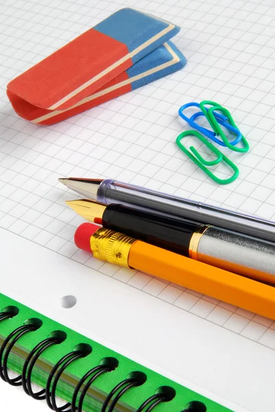 Lápiz, lápiz y gomas de borrar en un cuaderno — Foto de Stock