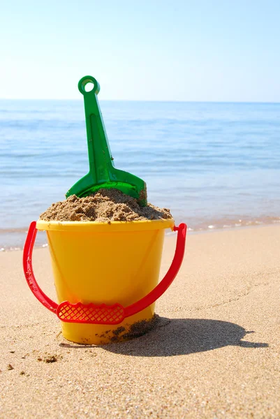 Shovel and bucket at the seashore — Stock Photo, Image