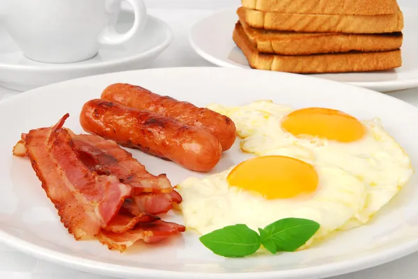 Breakfast. Fried eggs, bacon and sausages — Stock Photo, Image