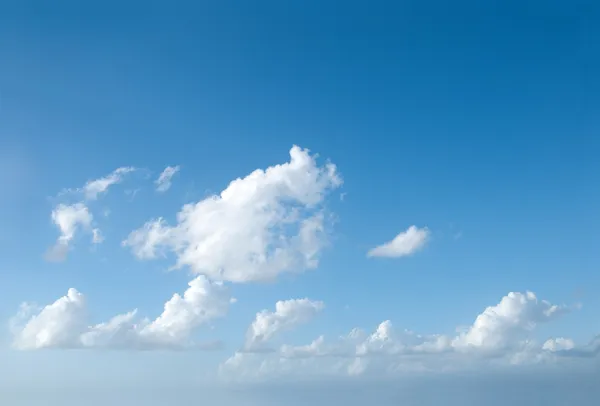 Blauwe hemel van de zomer met een paar wolken Stockfoto