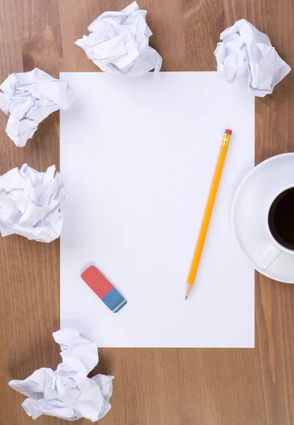 Crumpled paper balls and blank sheet of paper with pencil