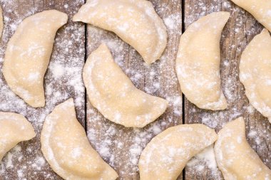 Ahşap masa üstünde pişmemiş pierogi