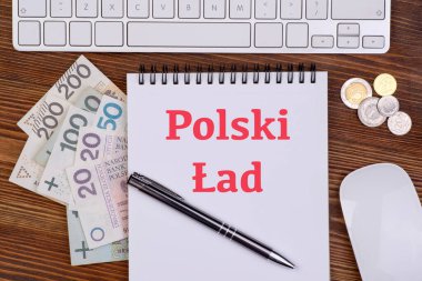 Polonya 'da yeni vergi yasası Polski reklamı, Polski Lad yazılı defter, Polonya banknotları ve bozuk paralar ve masa üzerinde bilgisayar klavyesi ve fare, üst görünüm 
