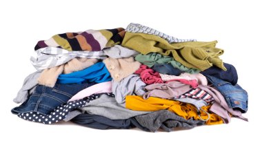 Beyaz arka planda izole edilmiş süveterler, pantolonlar ve gömlekler gibi rengarenk giysiler yığını. 