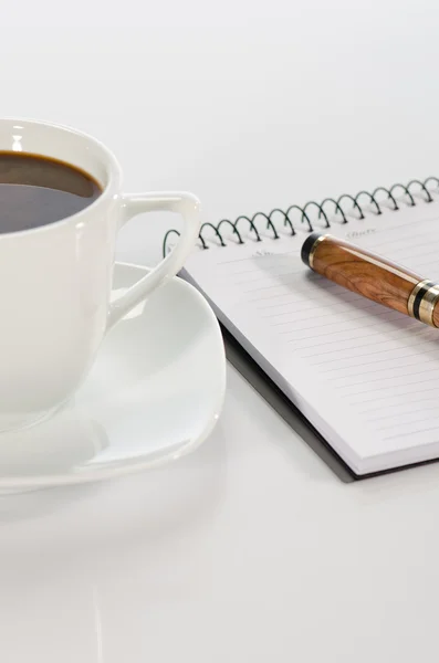 Cup of coffee, pen and notebook