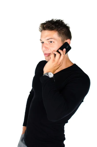 Giovane uomo con il telefono cellulare in piedi su sfondo bianco — Foto Stock