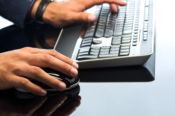 Mãos de homem trabalhando com mouse e teclado de computador — Fotografia de Stock