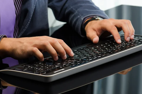 Man's hands working on computer keyboard — Stock Photo, Image