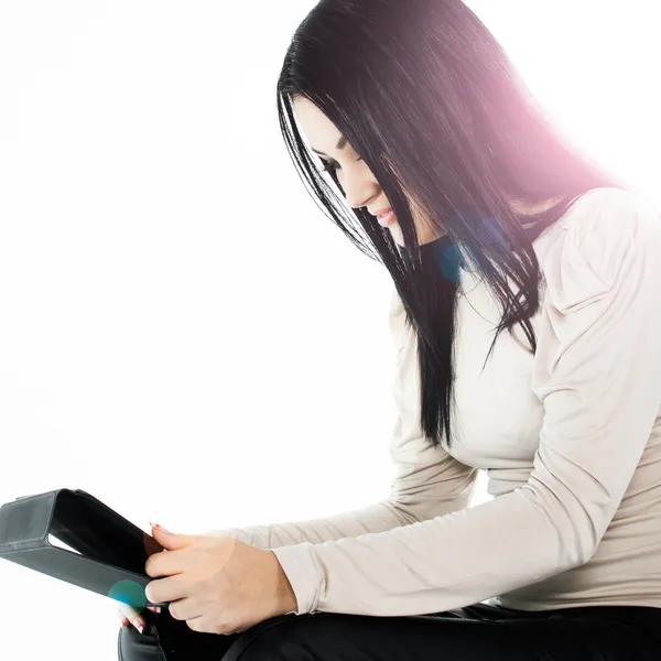 Beautiful brunette sitting on the floor and using a tablet — Stock Photo, Image