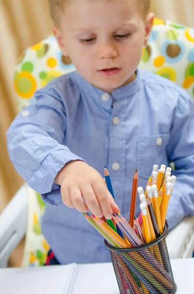 Beautiful child choose between more colored pencil — Stock Photo, Image