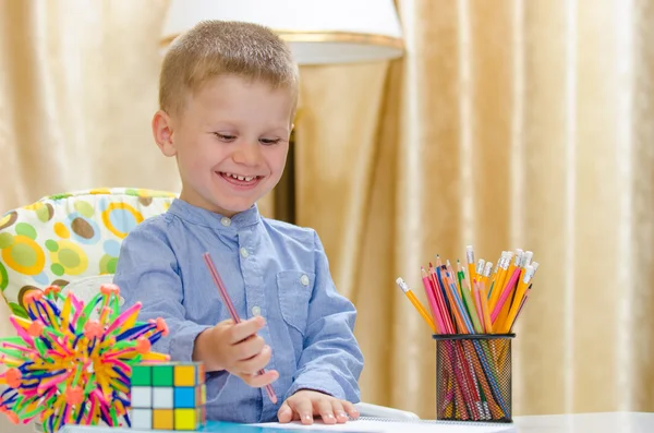 Criança bonita escrevendo com uma caneta vermelha — Fotografia de Stock