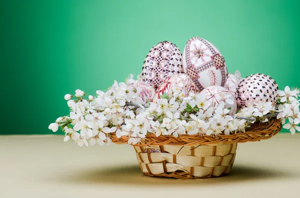 Cesta con huevos pintados de Pascua y flores de ciruela y cereza —  Fotos de Stock
