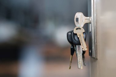 Arka planı bulanık, seçici odaklı, kapı anahtar deliğinde anahtarlık demeti