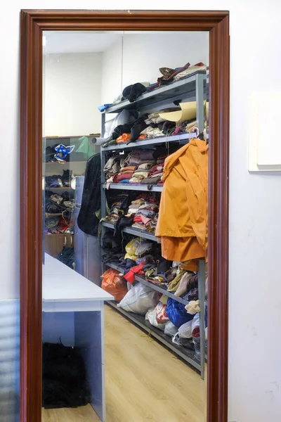 Mnohobarevné Různé Oblečení Naskládané Hromadách Polici Reflektující Velké Zrcadlo Ateliéru — Stock fotografie