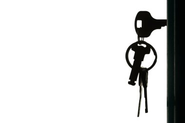 Anahtarlığı olan anahtarların silueti beyaz arkaplanda izole edilmiş anahtar deliğinde