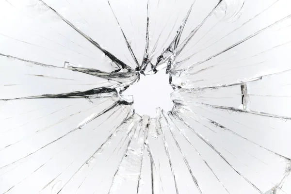The hole in the broken and cracked glass, closeup