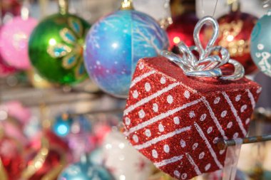 Bir hediye kutusunu ve çeşitli renkli Noel balolarını kapayın. Bulanık mücevherlerle donatılmış, seçici bir odak noktası olsun.