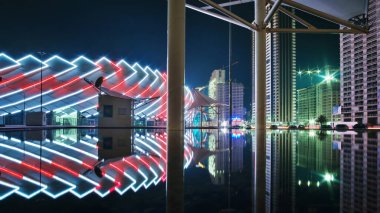 Batumi, Gürcistan, 27 Ekim 2021: Su yüzeyine yansıyan modern mimari ile renkli aydınlatılmış stadyum ve gece şehri 