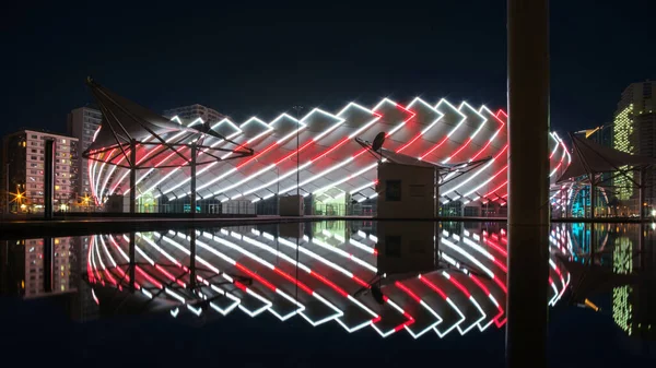 Vista Nocturna Construcción Moderna Iluminada Del Edificio Reflejándose Una Superficie — Foto de Stock