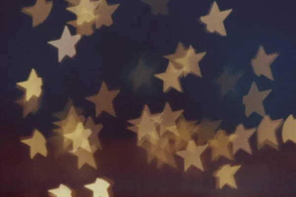 Golden stars light bokeh background. Christmas abstract pattern.