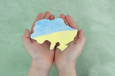 Ukraynalı çocuk Ukrayna haritasını elinde tutuyor. Ukrayna kavramına bağlı kal. Ülkemi kurtar..