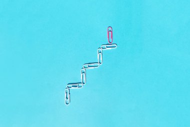 Mavi arka planda ataçlar. Başarı, büyüme kavramı.