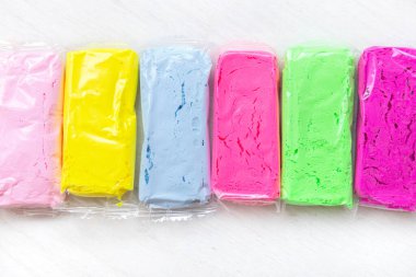 Çok renkli kil sıvısı ya da ahşap beyaz masa üzerindeki hamur.