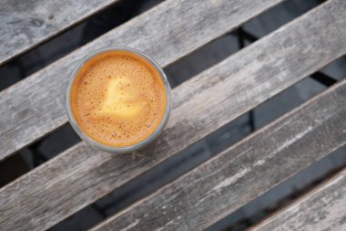 Son moda kahve içeceği Capuorange 'ın masa üstü görüntüsü. Portakal suyu ve espresso karışımı. Arka planda ahşap tahtalar olan bir içkinin en iyi görüntüsü..