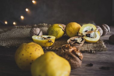 Ahşap masada ayva ve fındık. Sonbahar hasat konsepti. Sonbahar kırsal yaşamı. Çekirdekli ve cevizli ayva. Olgun organik yiyecekler. Mevsimlik tatlı.