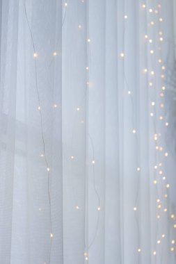 Beyaz perdedeki elektrik hattı. Tatil dekorasyonu. Soyut Noel arkaplanı. Şenlikli iç tasarım. Beyaz arka planda peri ışıkları. Gizemli illüstrasyon. 