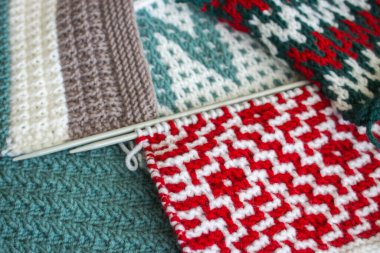 Örgü yün ve örgü iğneleri. Çeşitli örgü kalıpları. Sıcak el yapımı ekose. Yamalı battaniye. Sıcak, sıcak bir bez. İplik tığ işi. Kış yün deseni. Noel örgü battaniyesi. Kış hobisi.