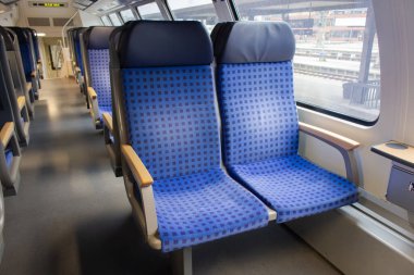 Avrupa 'daki yolcu treninin içi. Boş tren vagonu. Trendeki mavi rahat koltuklar. Almanya 'ya yolculuk. Seyahat yerleri kavramı. Demiryolu taşımacılığı. İnsansız toplu taşıma. Turizm ve tatil kavramı. 