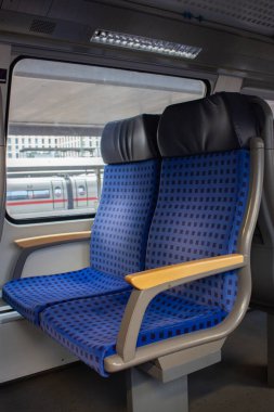 Avrupa 'daki yolcu treninin içi. Boş tren vagonu. Trendeki mavi rahat koltuklar. Almanya 'ya yolculuk. Seyahat yerleri kavramı. Demiryolu taşımacılığı. İnsansız toplu taşıma. Turizm ve tatil kavramı. 