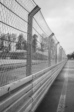 Metal çit perspektifte, siyah beyaz. Güvenlik ve güvenlik kavramı. Metalik tel bariyer. Demir sınır. Çelik kapı. Koruma konsepti. Suç hücresi. Sanayi mimarisi.