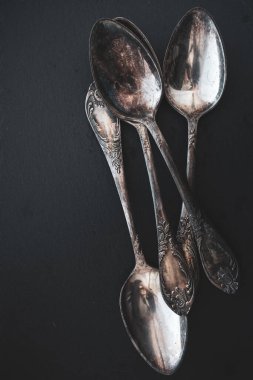 Siyah arka planda antika çatal bıçak takımı. Gümüş kaşıklar izole edildi. Kopya alanı olan gümüş takımlar. Gümüş çatal bıçak takımı. Modaya uygun retro aletler. Eski mutfak aletleri. Siyah üzerine zarif bir alet..