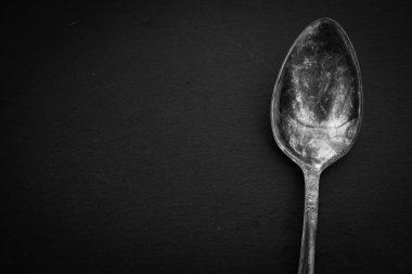 Siyah arka planda antika çatal bıçak takımı. Gümüş kaşık izole, siyah ve beyaz. Kopya alanı olan gümüş takımlar. Gümüş çatal bıçak takımı. Modaya uygun retro aletler. Eski mutfak aletleri. Siyah üzerine zarif bir alet..