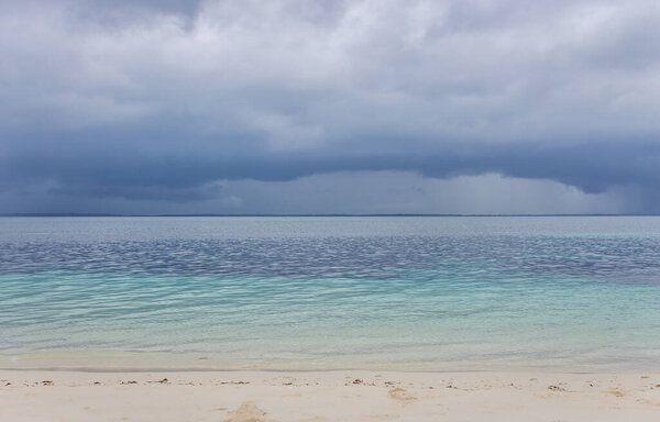 Aerial tropical seascape before storm. Rainy clouds over tropical sea. Paradise landscape. Summer vacations in tropics. Tropical nature. Amazing cloudscape with indian ocean.