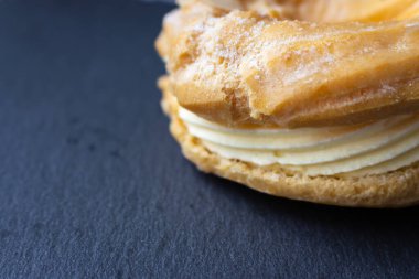 Kremalı tatlı çörek. Siyah arka planda taze kremalı çörek. Fırında hamur işi. Ricotta ile tatlı rulo. Lezzetli tatlı. Ev yapımı mutfak. Tatlı yemek. Jöleli çörek. Vanilyalı kremalı çörek..