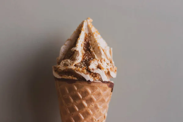雪糕锥在灰色的墙壁背景与复制空间 华夫饼中的焦糖冰淇淋 奶油甜点 更新冰冷的甜点 融化的冰淇淋 夏天的生活方式甜食概念 — 图库照片