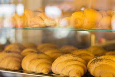 Taze pişmiş kruvasan. Vitrindeki taze kruvasanlar. Ev yapımı hamur işi. Marketteki fırın. Ekmek satışı. Kahvaltı konsepti. Sabah kahvesinde lezzetli kruvasanlar. Ev yapımı yemek.. 