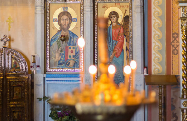 Ukraine, Kyiv - 06.14.2022: Interior Pyrohoshcha Dormition of the Mother of God Church. Unfocused glowing candles with icons on background. Orthodox church interior. Religious architecure. Faith and hope. 