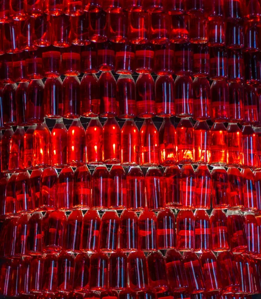 Red bottles background. Creative bar design. Wine bottles with red light. Winery decoration. Red wine concept. Alcohol drinks concept. Red color background.