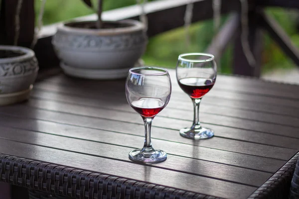 Two glasses of red wine in wooden table. Elegant wine party. Alcoholic drinks. Summer relax with wine. Romance concept. Vineyard in provence. Red wine concept. Wine for two.