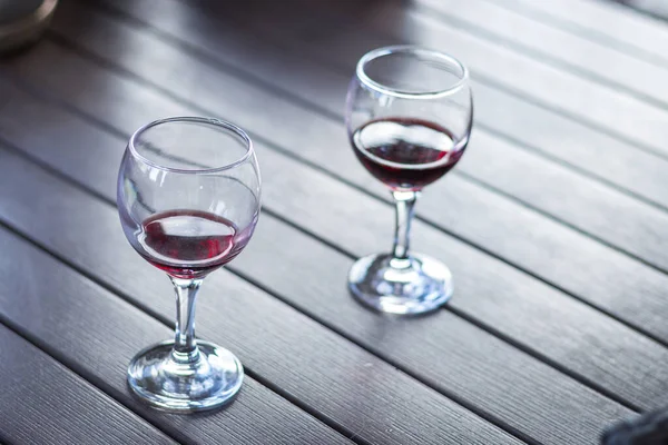 Two glasses of red wine in wooden table. Elegant wine party. Alcoholic drinks. Summer relax with wine. Romance concept. Vineyard in provence. Red wine concept. Wine for two.